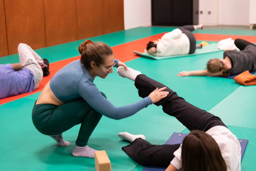 Estelle en train de corriger la position d'une élève de son cours de gym douce et relaxation à Cergy