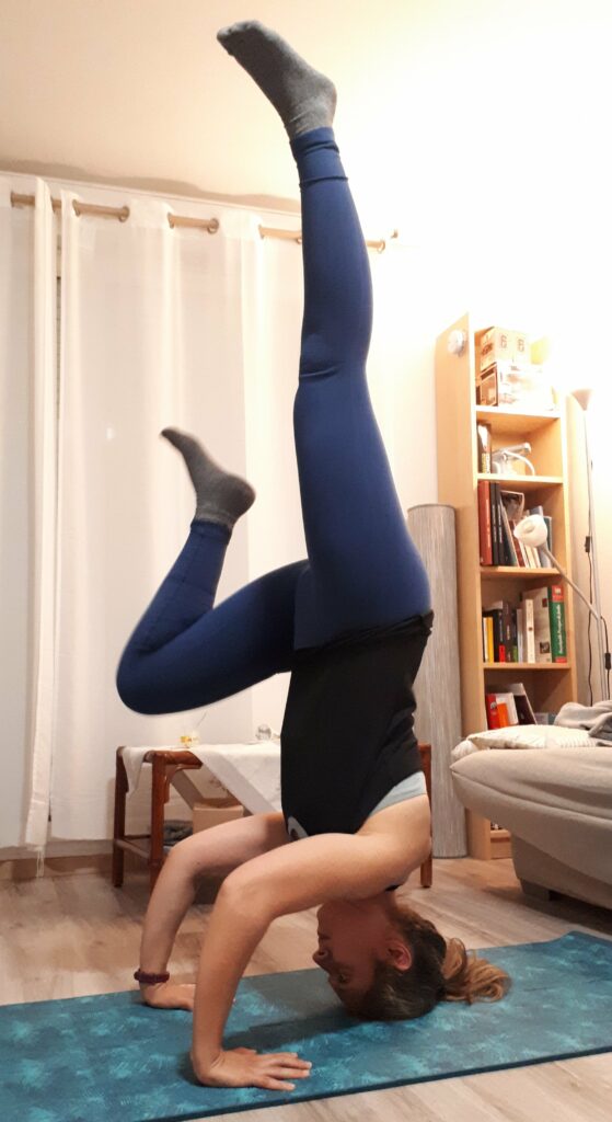 Une jeune yogi en posture d'inversion pour lâcher prise et accueillir ses peurs 